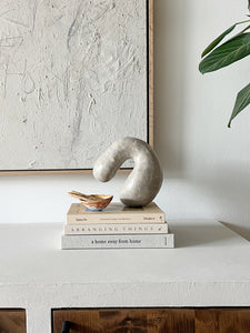 Styled shot of books and sculptural decor