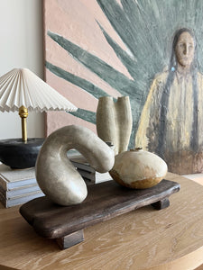styled shot of wooden board / riser and ceramics with a lamp