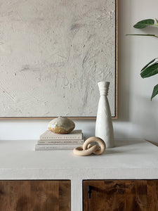 a styled vignette, including books, vases, and ceramic sculptures