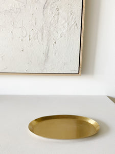 medium brass oval tray on white countertop