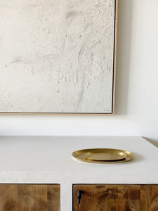 grouping of nestled brass oval tray on white countertop