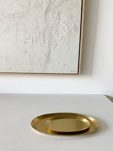 grouping of nestled brass oval tray on white countertop