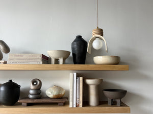 two floating shelves styled with ceramics and books